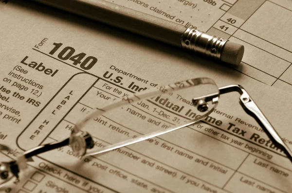 Daňové formuláře brýle a tužka Stock Snímky