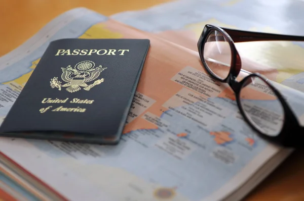 Pasaporte y gafas en el atlas —  Fotos de Stock