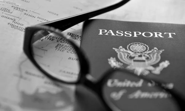 Pasaporte y gafas en el atlas — Foto de Stock