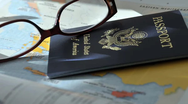 Pasaporte y gafas en el atlas —  Fotos de Stock