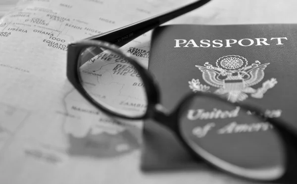 Passaporto e occhiali sull'atlante — Foto Stock