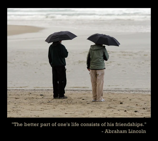 Men on the beach with umbrellas. — Stock Photo, Image