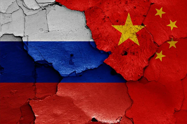Bandeiras Rússia China Pintadas Parede Rachada Fotografia De Stock