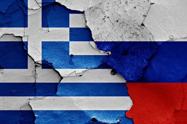 希腊和俄罗斯的国旗挂在裂开的墙上 — 图库照片