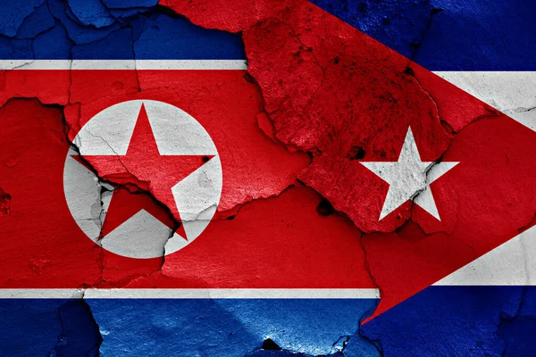 flags of North Korea and Cuba painted on cracked wall