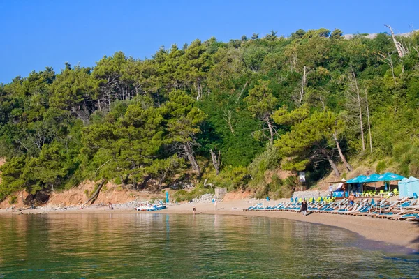 MONTENEGRO, BUDVA - JULY 12, 2015: Tourists on famous Mogren beach near Budva in Montenegro. Sandy beach is located in 150 m away from the old city — Stock Photo, Image