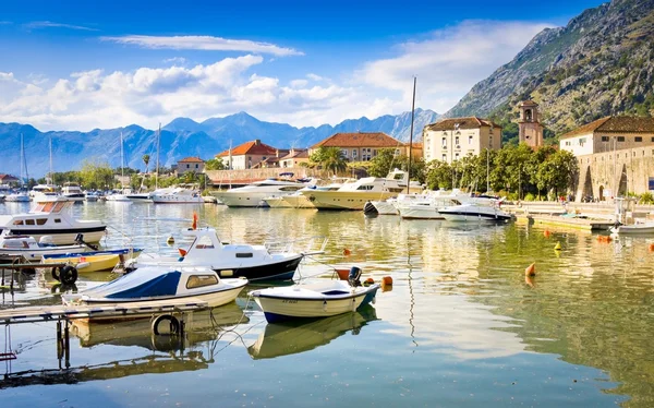 Kotor, Černá Hora - 24. června 2015: Lodě v moři při západu slunce s horami a staré město na pozadí — Stock fotografie