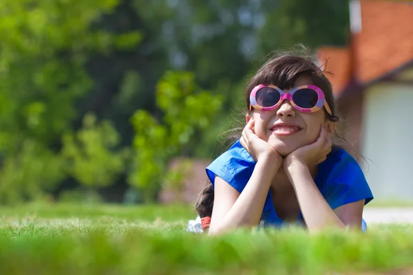 Smiling girl laying against new cottages — Stock Photo, Image