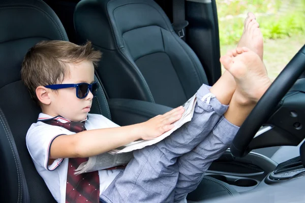 Милый водитель читает газету в машине Лицензионные Стоковые Фото