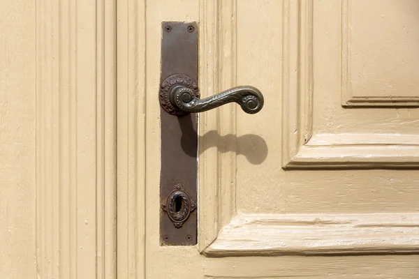 Old and used door handle on a wooden door — Stock Photo, Image