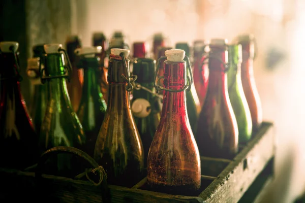 Oude bierflesjes in houten gevallen — Stockfoto