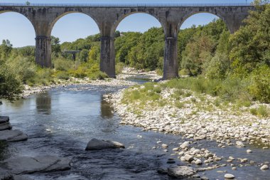 Bridge crossing the Ardeche river near the town of Vogue, France clipart