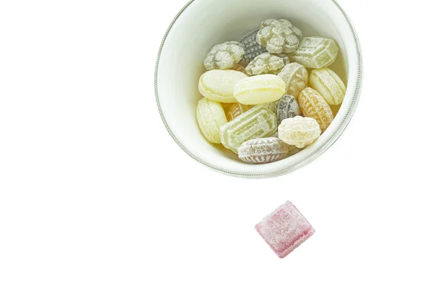 Auswahl an Bonbons in einer kleinen Schüssel auf weiß — Stockfoto