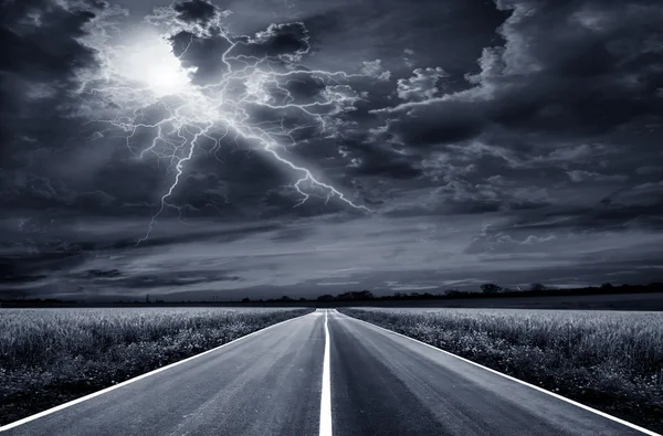 Paved road through a field of wheat at night. — Stock Photo, Image