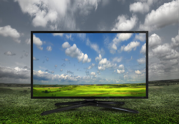 4k Modern television on a green meadow, showing the colors more 