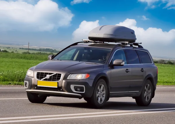 Carro Volvo na estrada com um porta-malas de viagem — Fotografia de Stock
