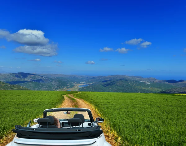 White convertible on a country road through fields — Stock Photo, Image