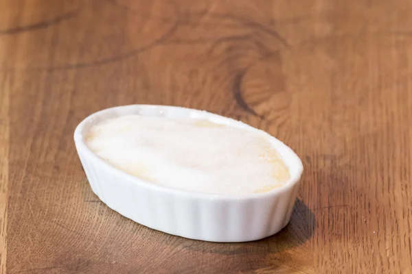 Catalan cream on wooden table in white bowl — Stock Photo, Image
