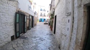 Mavi Köy olarak bilinen Casamassima, İtalya 'nın karakteristik caddesinde parlak bir yürüyüş. Video, ortaçağ tarihi merkezinin taş kaldırımlarını, beyaz perdeleri ve geleneksel mimarisini çekiyor..