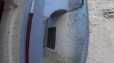 İtalya 'nın Casamassima kentindeki karakteristik bir ortaçağ caddesinde huzurlu bir yürüyüş tarihi Apulia Mavi Köyü' nde. Taş evler, eski ahşap panjurlar, dar sokaklar ve antik kasaba merkezinde otantik Akdeniz atmosferi..