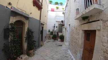 İtalya 'nın Casamassima şehrindeki dar bir ortaçağ caddesinde, Apulia' nın ünlü Mavi Köyü 'nde yavaş bir yürüyüş. Taş duvarlar, küçük balkonlar, tarihi geçitler ve eski kasabanın sessiz cazibesi..