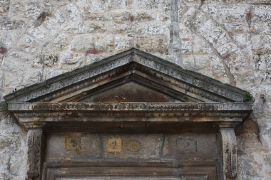 Tarihi Casamassima 'nın merkezinde klasik üçgen pedikürlü yıpranmış taş kapı aralığı. Eski dokular, soluk oymalar ve kırsal masonluk eski şehrin geleneksel mimarisini ön plana çıkarıyor.