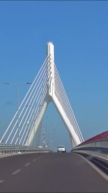 Bari İtalya 'daki Adriyatik Köprüsü' nün 4K dikey videosu, mavi gökyüzü kentsel atmosfer trafik perspektifi ve güçlü mimari simetrisiyle yol boyunca çekilmiş modern bir kablo yapısı.