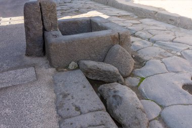 Antik Roma 'nın güney İtalya' daki Pompeii arkeoloji sahasındaki bir cadde boyunca uzanan basamak taşlarına yakından bakın. Taş bloklar caddeleri geçmek ve Roma şehrinde su akışını yönetmek için kullanıldı..