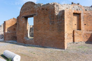 Güney İtalya 'daki Pompeii arkeoloji sahasında kemerli bir kapısı olan antik bir Roma tuğla binasının manzarası. Yapı, MS 79 'dan önce Roma inşaat teknikleri ve kent mimarisini gösteriyor..