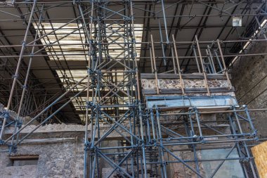 Pompeii 'deki antik Roma harabelerinde restorasyonu destekleyen yapı iskelesi. Koruma çabaları zaman ve volkanik patlamadan zarar gören tarihi binaları koruyor.