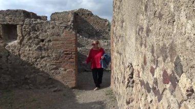Pompeii 'deki antik bir Roma evine giren turist, antik kentin korunmuş iç mimarisini gözler önüne seren dar taş geçitlerden geçiyor..