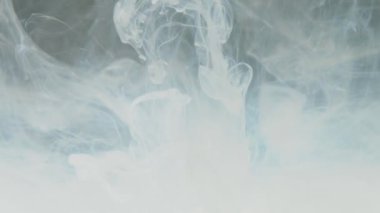 Soyut beyaz boyanın orta boy yakın çekimi suda yavaşça çözünür.