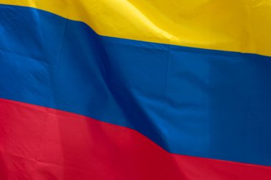 Rüzgârla dalgalanan Kolombiya bayrağına yakın. Milliyet ve ülke kavramı