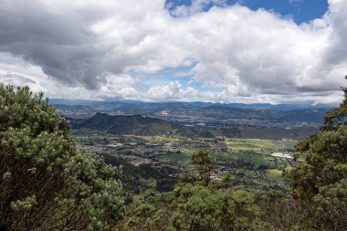 İnanılmaz bir dağ manzarası, yeşil kırsal alanlar ve arka plandaki dağ vadisi tepeleri..