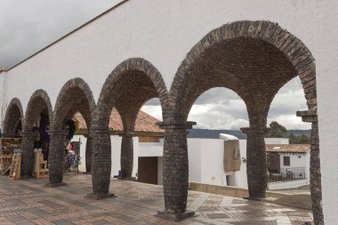 GuatAVITA, COLOMBIA - Tuğla yay ve pillalar güneşli bir günde kilise meydanındaki bir gif dükkanına bir ara sokak oluşturuyorlar