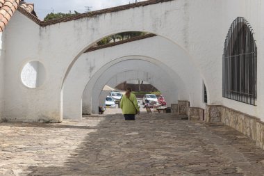 Güneşli bir günde Kolombiya 'nın Guatavita kasabasının aşağısında Ark Caddesi' nde yürüyen bir kadın turiste yakın..