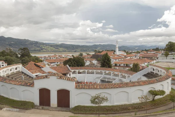 GUATAVITA, COLOMBIA - Guatavita şehir manzarası önde ve arka planda andean moutnains gri gökyüzünde öğleden sonra