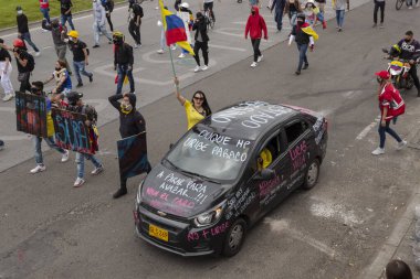 BOGOTA, COLOMBIA - 20 Mayıs 2021 Hroes Anıtı 'nda hükümete karşı ulusal yürüyüşler sırasında Kolombiya bayrağı taşıyan genç bir kadın protestocu