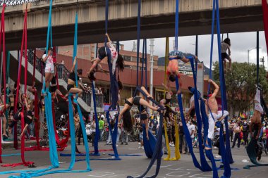 BOGOTA, COLOMBIA - 20 Mayıs 2021 Kolombiya paro ulusal yürüyüşleri sırasında Heroes Transmilenio otobüs durağı peatonal köprüsünde hükümete karşı hava dansı sokak sanatı gösterisi