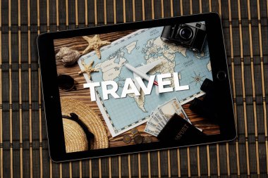 Bir tablete yakın seyahat konsepti ve ahşap arka plan üzerinde tabirle seyahat