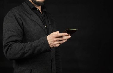 Ekranın sol tarafında, sağ eliyle cep telefonu tutan modern bir iş adamına yaklaş.