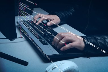 Bir bilgisayar klavyesine dijital kod yazan programlanmış bir erkek ele yakın.