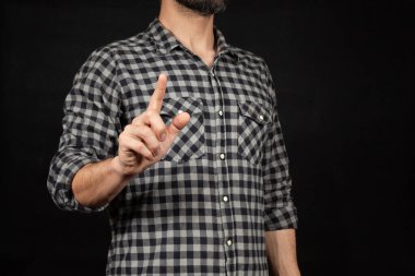 Sağ işaret parmağıyla gökyüzünü gösteren sakallı bir adama yaklaş. Önünde siyah bir arkaplan var.