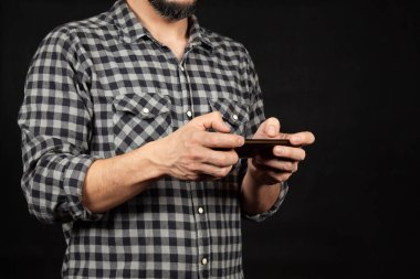 Ekranın sol tarafında iki eli önünde akıllı bir telefon tutan bir adama yaklaş.