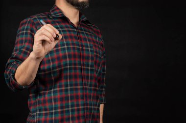 Oduncu tişörtü giyen genç bir adama yaklaş. Sağ eli önündeki boşlukta yazıyor.