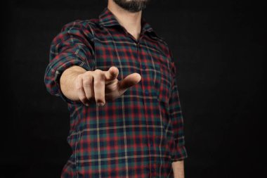 Oduncu tişörtü giymiş bir adama yaklaş. Sağ işaret parmağıyla önündeki boşluğu göster.