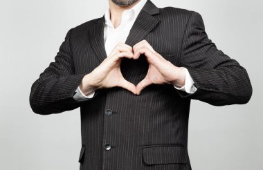 Takım elbiseli bir işadamının, elleri göğsünde ve beyaz bir geçmişle aşk ya da kalp sembolü çizmesine çok yakınım.