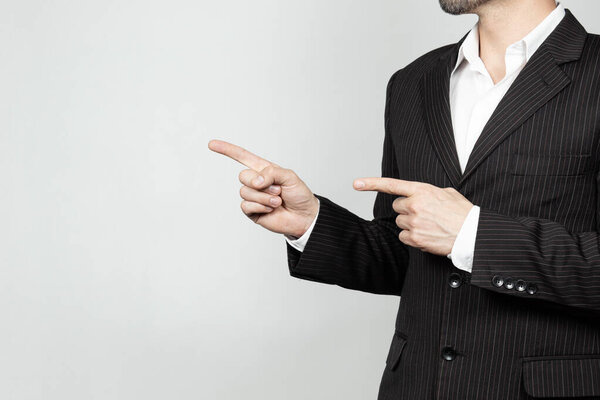 Ближе к бизнесмену в костюме справа от экрана, готовому показать что-нибудь с руками на затемненном пространстве.