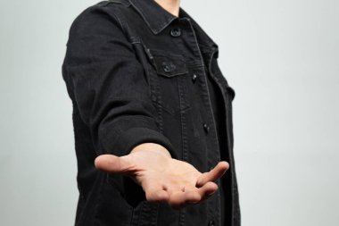 Siyah kot ceketli bir adama yaklaş. Uzayda bir şey tutmaya hazır. Elleri ve beyaz bir arka planı var.