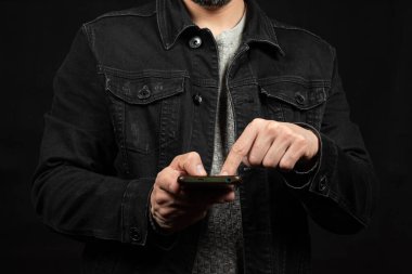 Siyah kot ceketli bir adama yaklaş sol işaret parmağıyla akıllı telefon ekranını göster.